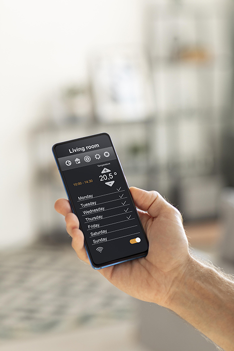 person-holding-smartphone-with-home-automation-app person holding smartphone